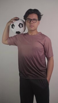 Southeast Asian person is carrying soccer ball on his shoulders