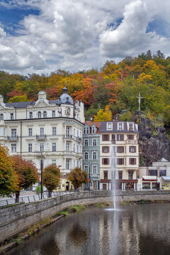 Grandhotel Pupp, Karlovy Vary, Czech Republic. Corner view with Tepla River and hillside crucifix under soft daylight