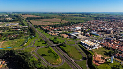 Fototapeta premium An aerial view of a city with a highway and green spaces under a clear blue sky