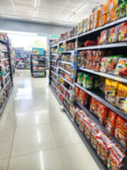 Obraz premium Blurred background of colorful snack and food products on supermarket shelves.