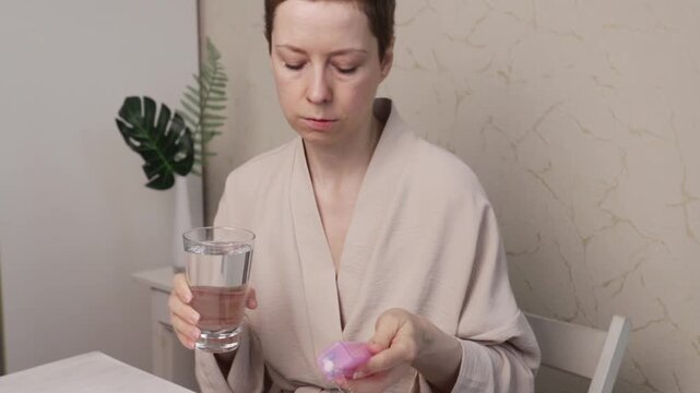 patient holds water and pill organizer, daily medication adherence and therapy routine concept