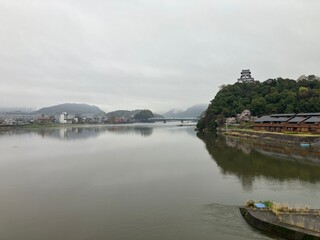 Obraz premium View of Inuyama Castle and Kiso River with cherry blossoms on a cloudy day, Japan