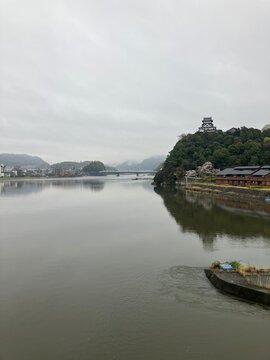 Vertical view of Inuyama Castle and Kiso River with cherry blossoms, Japan