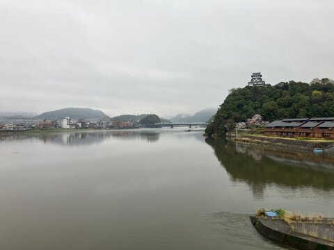 View of Inuyama Castle and Kiso River with cherry blossoms on a cloudy day, Japan