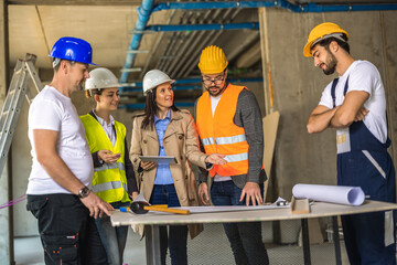 Female construction manager leading a site meeting with a diverse engineering team.