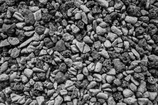 Black‑and‑white close‑up of textured stones forming a rough natural background, highlighting detailed surface patterns for use in design and abstract compositions.