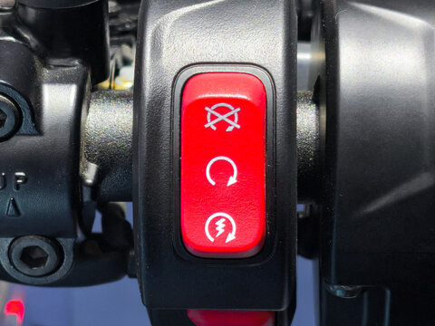 Red Motorcycle Kill Switch and Starter Button on Black Handlebar