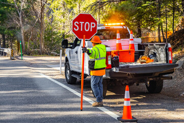 Road Worker Holding Stop Sign Regulating Traffic Flow © PhotoSpirit
