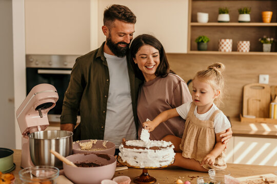 Happy family baking cake together in kitchen