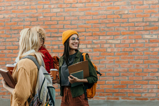 Diverse students carrying books and coffee on college campus