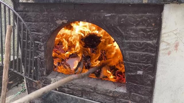 A fire burns in a fireplace. Wood and paper burning in a fireplace to keep warm.
