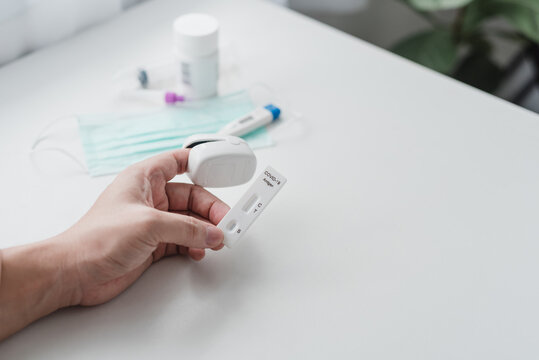 COVID-19 rapid antigen test and pulse oximeter held by hand for home healthcare diagnostic and health monitoring