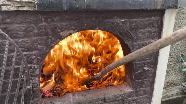 A fire burns in a fireplace. Wood and paper burning in a fireplace to keep warm.