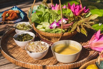 Traditional Thai food set with fresh organic vegetables and lotus flowers for healthy lifestyle and cultural dining