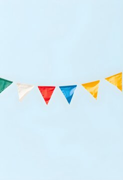 Colorful triangular flags on a string against light blue background