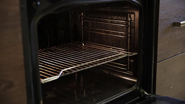 Man's Hands Placing a Tray of Crepe Rolls into an Open Oven