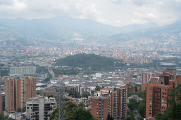 Fototapeta premium Medellin city panorama showcasing a vast urban landscape nestled within the aburra valley. Surrounded by rolling mountains under a cloudy sky