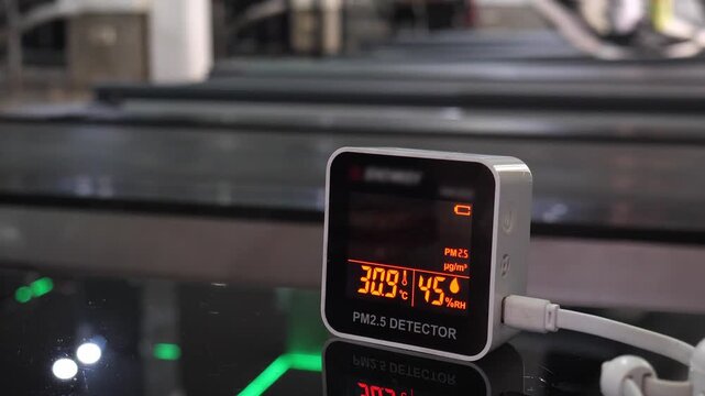 Digital air quality detector showing high hazardous PM 2.5 levels with red warning display for pollution and health concept