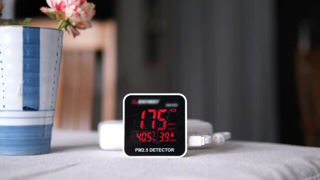 Digital air quality detector showing high hazardous PM 2.5 levels with red warning display for pollution and health concept