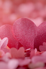 Obraz premium A pink heart surrounded by numerous pink flowers. vertical frame