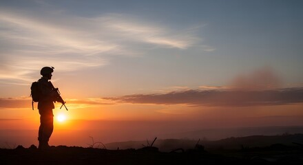 Obraz premium Silhouette of a soldier standing guard on a hill during a dramatic sunset
