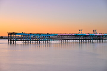 Fototapeta premium Mining pier of Huelva glowing in the golden dusk light
