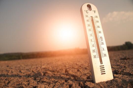 Thermometer showing high temperature under strong sunlight heat levels and climate crisis.