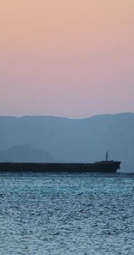 Cargo Ship Sailing Past Desert Mountains at Cinematic Sunrise | T1.2 Lens, 4K, 12-Bit Braw HQ Vertical Video
