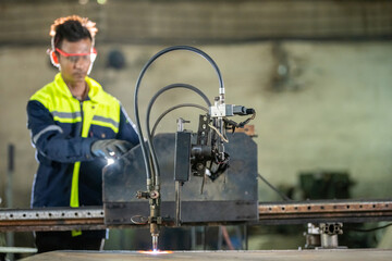 Fototapeta premium CNC Machine Operation: Male Engineer in Gloves and Safety Glass Cutting Metal with Sparks Technician Cutting Steel with CNC Machine in a Messy Old Factory Worker Using CNC for Steel with Heat