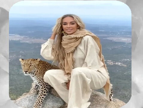 Woman posing with leopard on mountain top