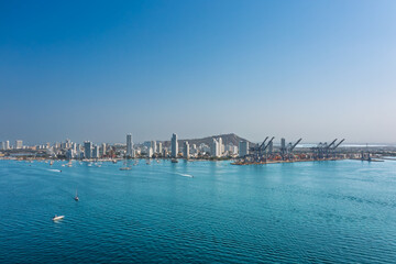 Obraz premium Panoramic view of the Cartagena skyline and industrial port in Colombia, featuring modern skyscrapers and boats on the blue Caribbean Sea