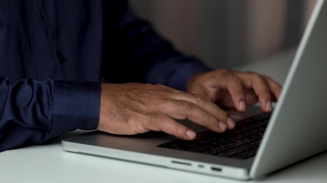 Close up of hands typing on laptop keyboard. Professional or businessman working on computer, entering text, managing information during daily business tasks at workplace Concept of office working