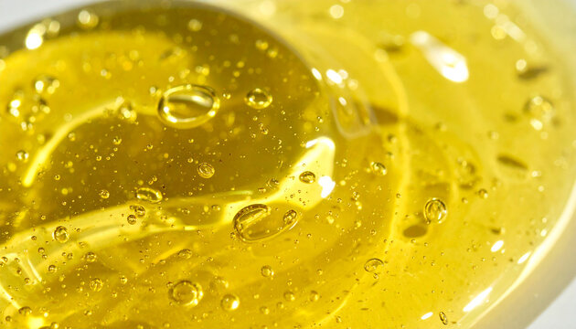 Yellow transparent skincare serum, thick gel texture with tiny bubbles inside, glossy and viscous consistency, cosmetic beauty product