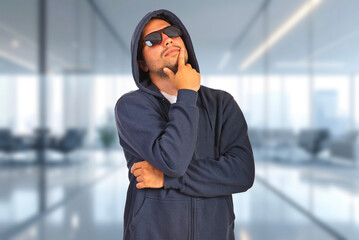 Fototapeta premium Man in hoodie and sunglasses appears thoughtful