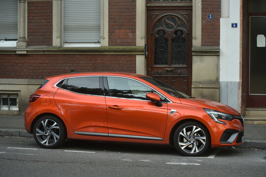 Mulhouse - France - 5 April 2026 - profile view of orange renault clio parked in the street