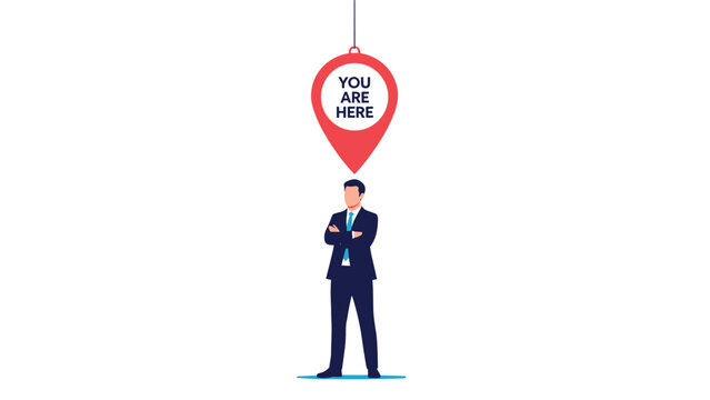 Businessman stands under large red location pin with you are here text representing identity and positioning.