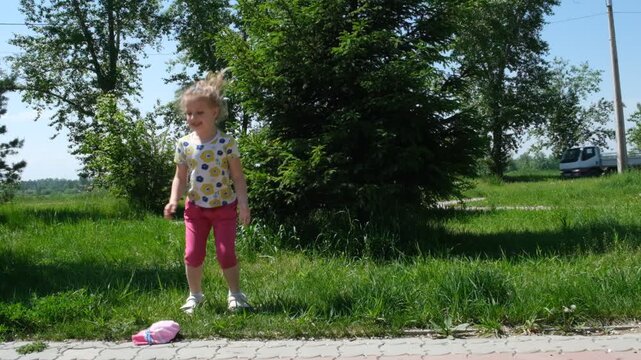 Pretty playful girl having fun outdoors. Healthy summer activity for children. Summer carefree time.