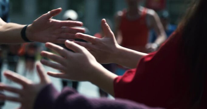 Runners at S25 Berlin city running event, high fives in Berlin, Germany