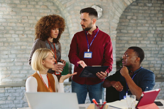 Woman leading a presentation to a diverse group of professionals in a modern office space