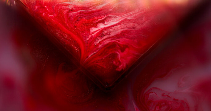Paint spilling. Glass cube angle. Blur red pink purple color geometric texture vibrant droplets on abstract vibrant art background.