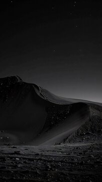 a black and white photo of the moon, its cratered surface sharply defined against a deep, starless night sky