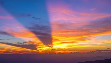 Fototapeta premium A colorful sunset over the ocean in Thailand, with vivid orange and pink skies reflecting on gentle waves and a distant boat silhouetted.