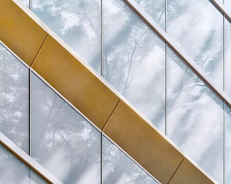 Modern glass office building facade reflecting pink trees with amber concrete frame for sustainable architecture and eco-friendly urban development editorial