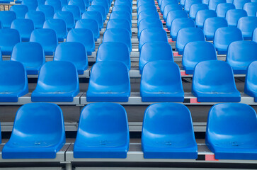 Fototapeta premium Empty blue plastic seats in symmetrical rows , abstract repeating pattern