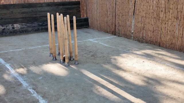 Traditional Spanish bolos huertanos wooden pins on sandy court with rolling ball during typical regional folk game in Murcia outdoor setting