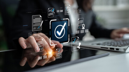 Business professional interacting with digital check mark interface while managing documents and...