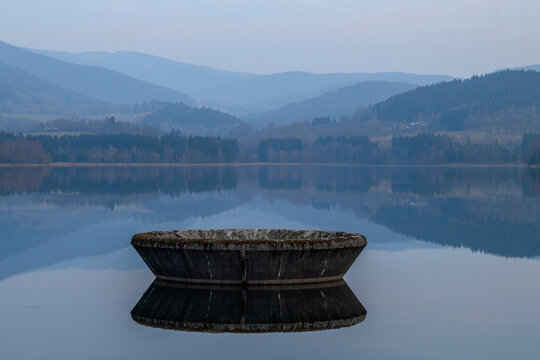 Nyrsko dam reservoir in cloudy spring dark evening with mountains