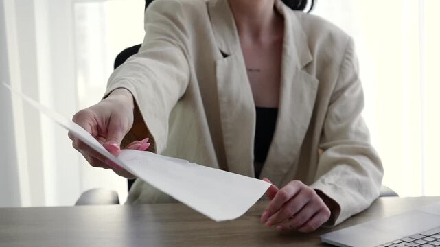 A woman in a management position.
Equality in work positions.
A female manager gives a document to sign.
The boss, who runs a financial company, sits in the office and gives a contract to sign.