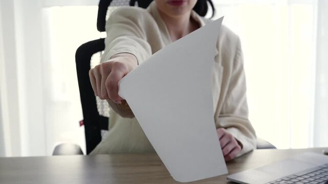 A woman in a management position.
Equality in work positions.
A female manager gives a document to sign.
The boss, who runs a financial company, sits in the office and gives a contract to sign.