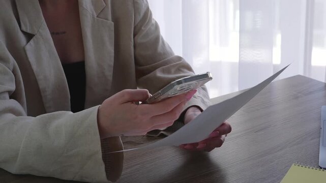 A woman in an office scans a QR code on a piece of paper to review documents.
Filling out paperwork and paying bills.
A woman holding a paper receipt.